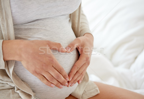 close up of pregnant woman making heart gesture Stock photo © dolgachov
