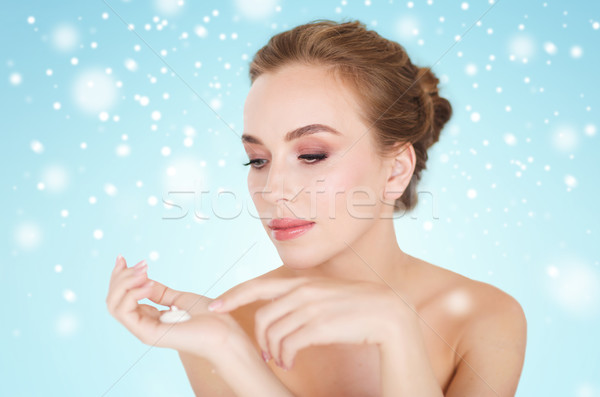 Stock photo: woman with moisturizing cream on hand over snow