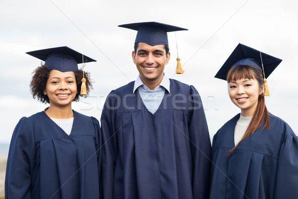 happy students or bachelors in mortar boards Stock photo © dolgachov