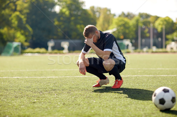 sad soccer player with ball on football field Stock photo © dolgachov
