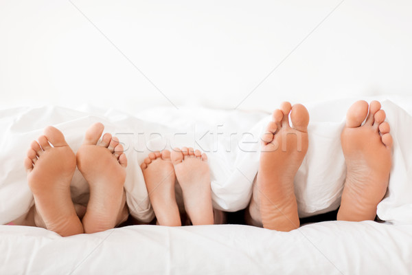 bare soles of happy family feet in bed at home Stock photo © dolgachov