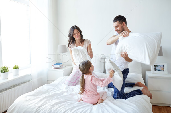 Szczęśliwą rodzinę pillow fight bed domu ludzi rodziny Zdjęcia stock © dolgachov