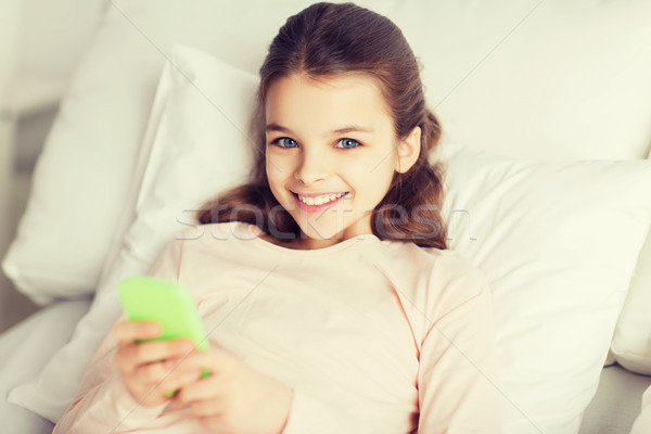 Fata de fericit pat smartphone acasă oameni copii Imagine de stoc © dolgachov