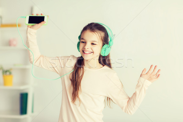 girl with smartphone and headphones at home Stock photo © dolgachov