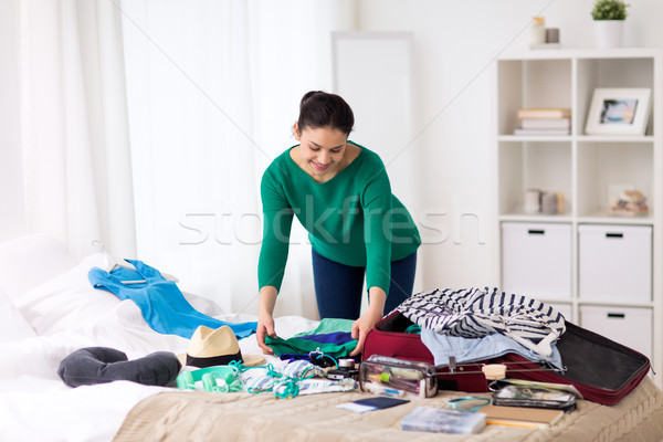 woman packing travel bag at home or hotel room Stock photo © dolgachov