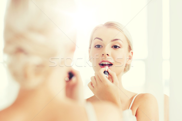 Stock photo: woman with lipstick applying make up at bathroom