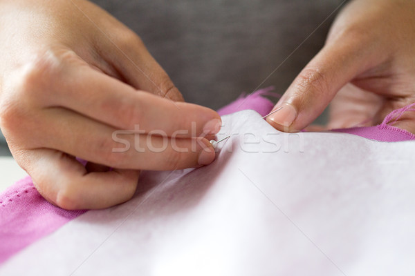 woman with pins stitching paper pattern to fabric Stock photo © dolgachov