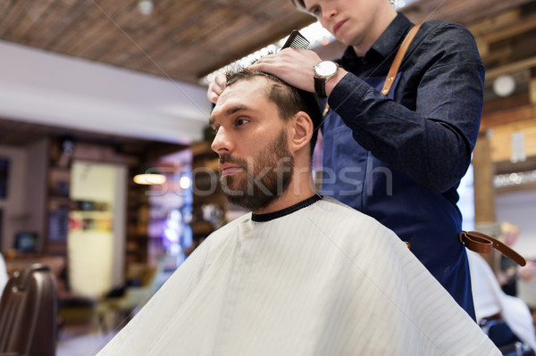 man and barber cutting hair at barbershop Stock photo © dolgachov