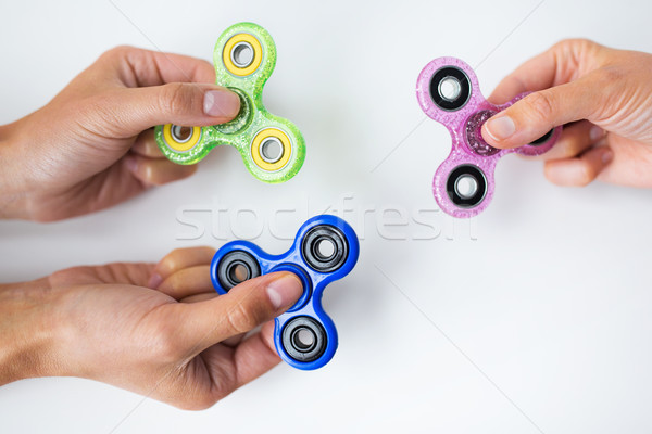 close up of hands playing with fidget spinners Stock photo © dolgachov