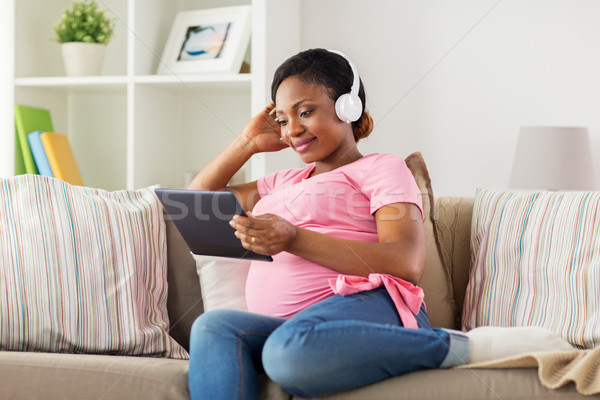 pregnant woman in headphones with tablet pc Stock photo © dolgachov