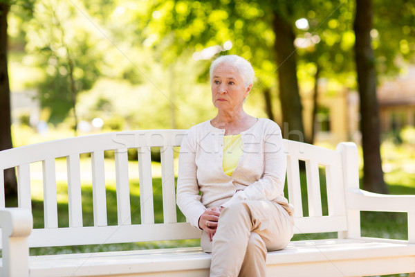 sad senior woman sitting on bench at summer park Stock photo © dolgachov