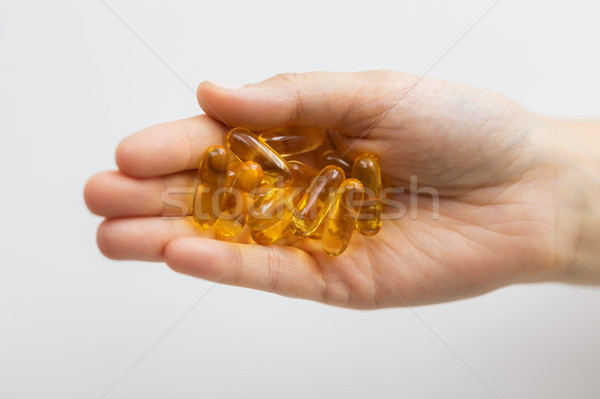 hand holding cod liver oil capsules Stock photo © dolgachov