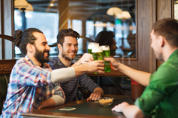 male friends drinking green beer at bar or pub Stock photo © dolgachov