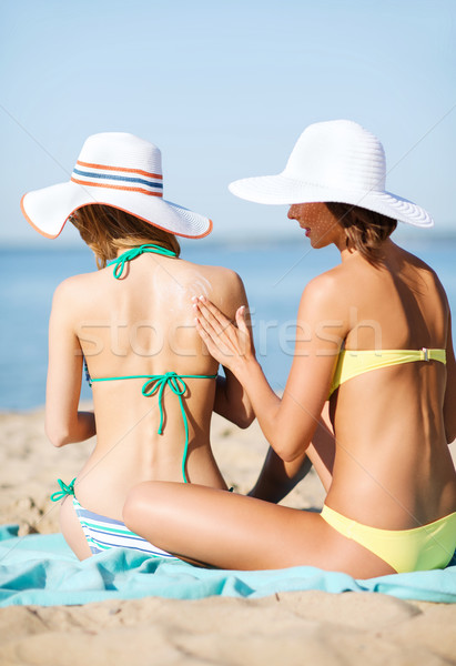 Lányok jelentkezik nap krém tengerpart nyár Stock fotó © dolgachov