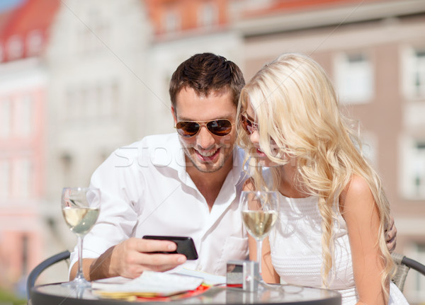 Stock photo: couple looking at smartphone in cafe