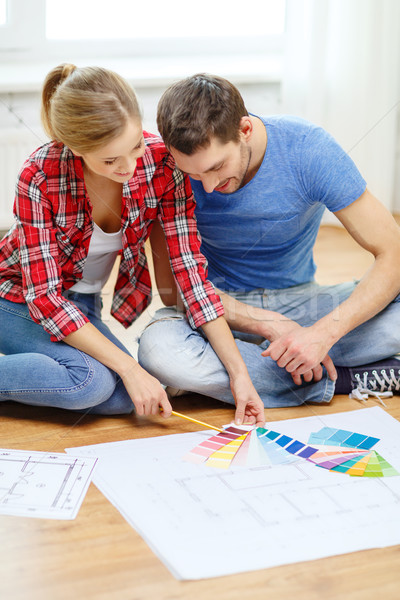 smiling couple looking at color samples at home Stock photo © dolgachov
