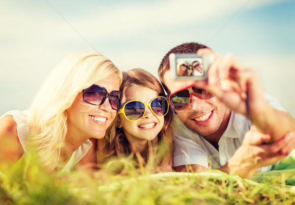 happy family with camera taking picture Stock photo © dolgachov