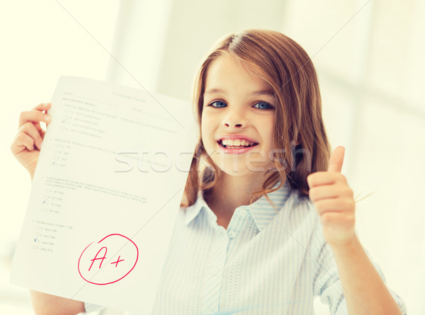 smiling little student girl with test and A grade Stock photo © dolgachov
