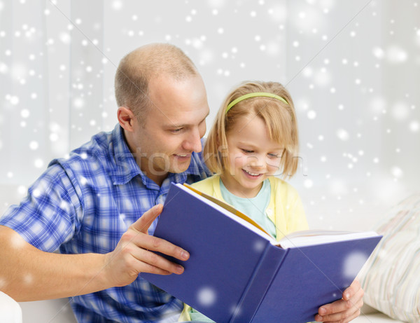 smiling father and daughter with book at home Stock photo © dolgachov