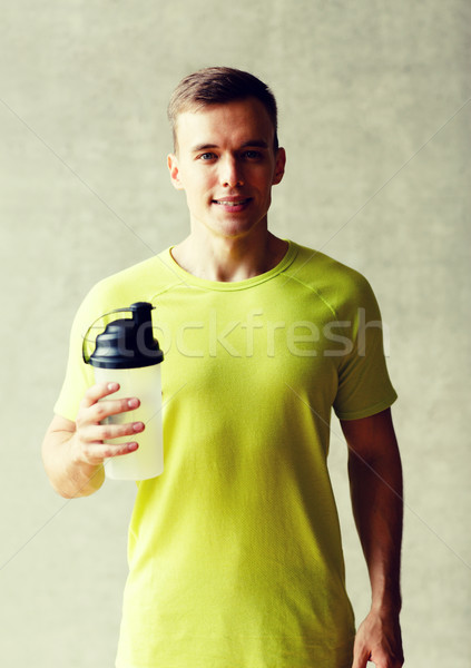 Mosolyog férfi fehérje shake üveg sport Stock fotó © dolgachov