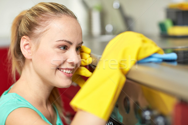 happy woman cleaning cooker at home kitchen Stock photo © dolgachov