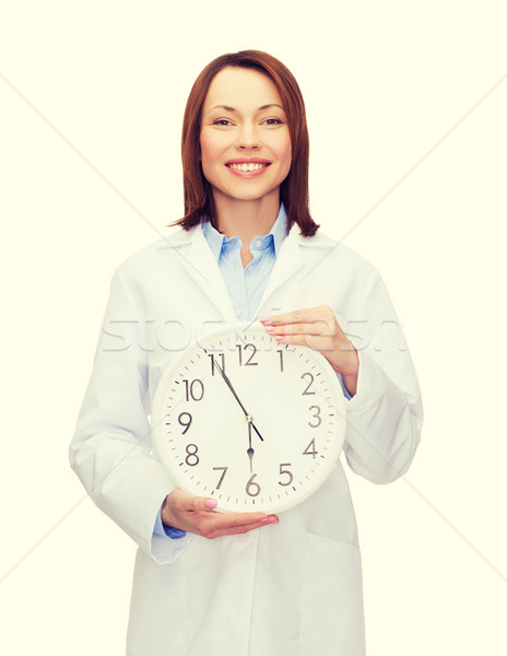 smiling female doctor with wall clock Stock photo © dolgachov