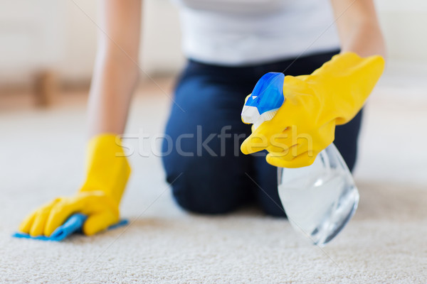 Stock photo: close up of woman with cloth cleaning carpet