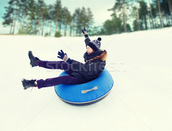 happy young man sliding down on snow tube Stock photo © dolgachov