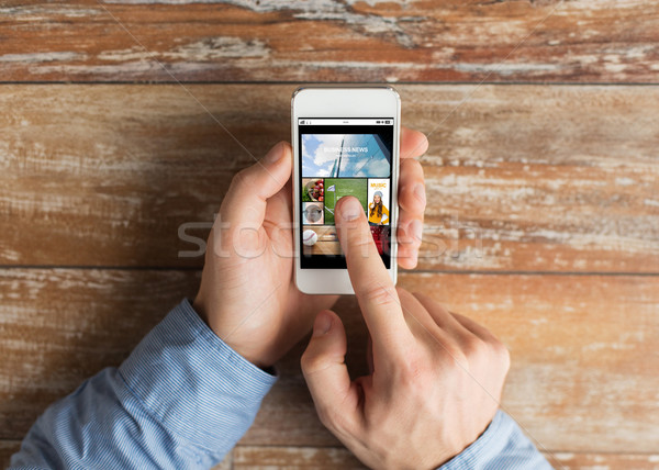close up of male hands with smartphone on table Stock photo © dolgachov