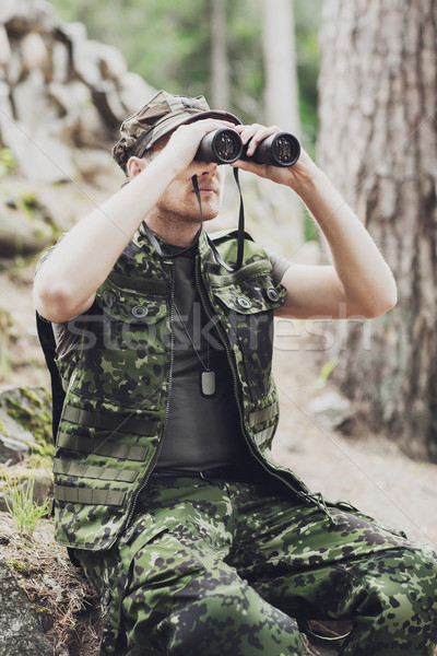 young soldier or hunter with binocular in forest Stock photo © dolgachov