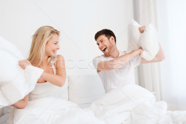 Feliz Pareja pelea de almohadas cama casa personas Foto stock © dolgachov