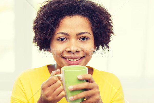 happy african american woman drinking from tea cup Stock photo © dolgachov