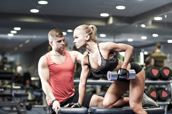 young couple with dumbbell flexing muscles in gym Stock photo © dolgachov