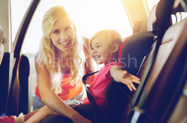 happy mother fastening child with car seat belt Stock photo © dolgachov