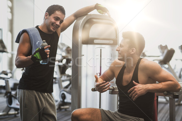 smiling men exercising on gym machine Stock photo © dolgachov