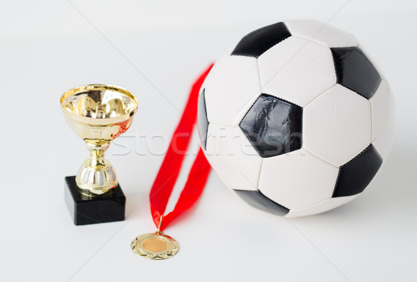 close up of football ball, golden cup and medal Stock photo © dolgachov