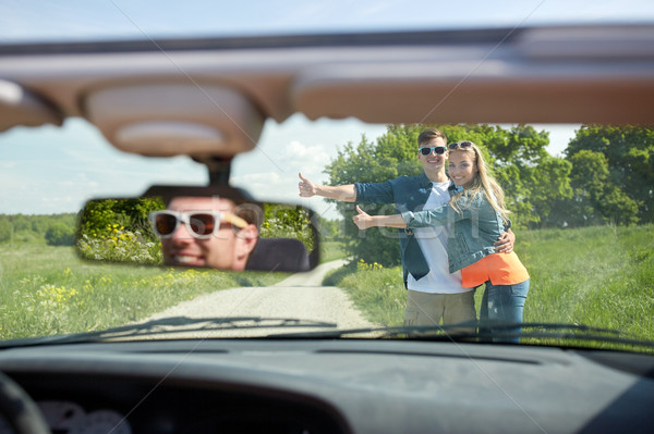 couple hitchhiking and stopping car on countryside Stock photo © dolgachov