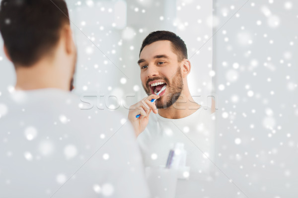 Homme brosse à dents nettoyage dents salle de bain [[stock_photo]] © dolgachov