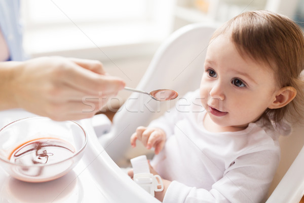 mother feeding baby with puree at home Stock photo © dolgachov