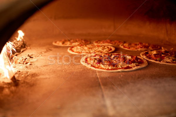 pizza baking in oven at pizzeria Stock photo © dolgachov