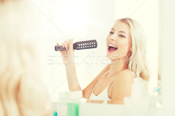 Feliz mulher cantando cabelo escove banheiro Foto stock © dolgachov