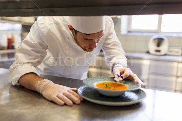 male chef decorating dish with pansy flower Stock photo © dolgachov