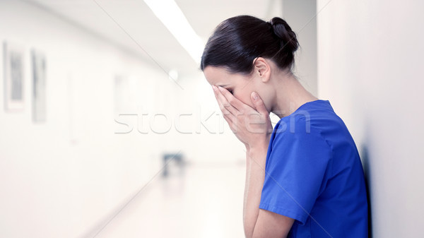 sad or crying female nurse at hospital corridor Stock photo © dolgachov