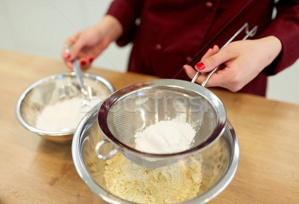 chef with flour in bowl making batter or dough Stock photo © dolgachov