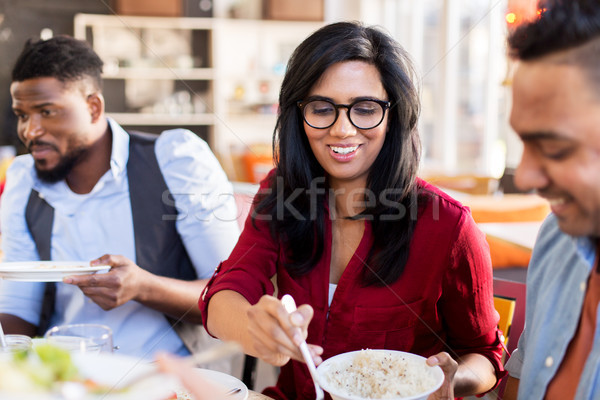 Stock photo: happy friends eating at restaurant