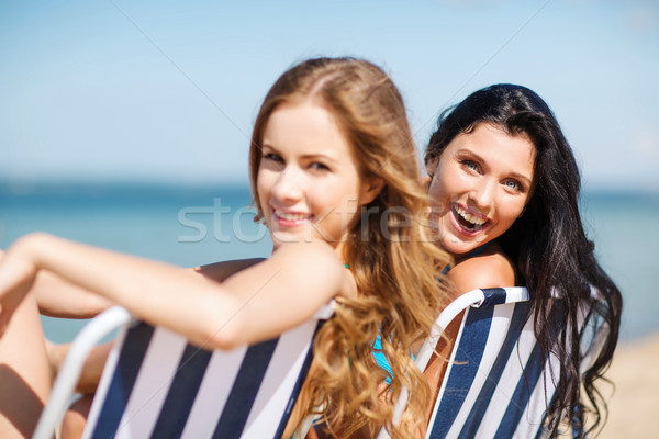 girls sunbathing on the beach chairs Stock photo © dolgachov