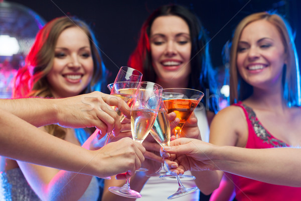 three smiling women with cocktails and disco ball Stock photo © dolgachov