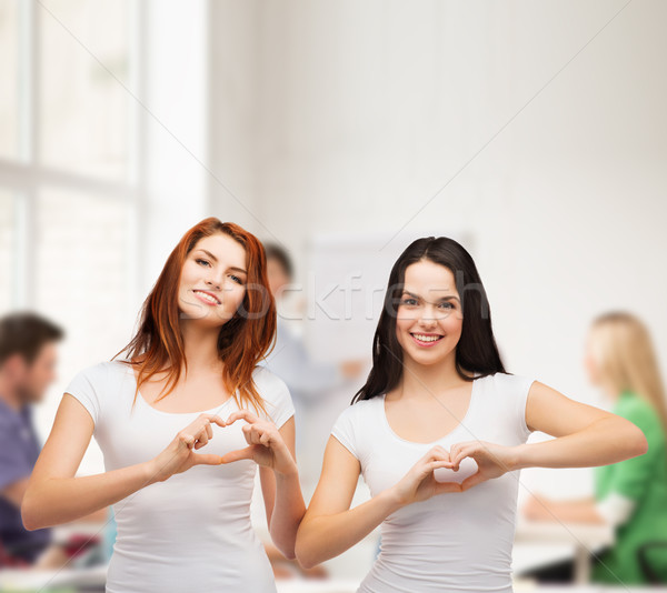 Zwei lächelnd Mädchen Herz Hände Stock foto © dolgachov