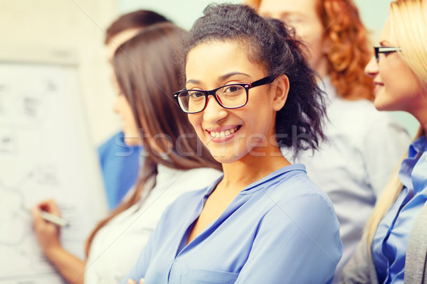 smiling businesswoman with team team on the back Stock photo © dolgachov