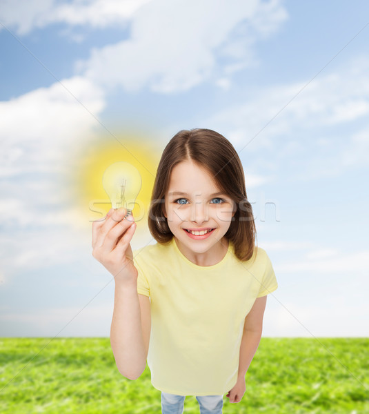 Stock photo: smiling little girl holding light bulb